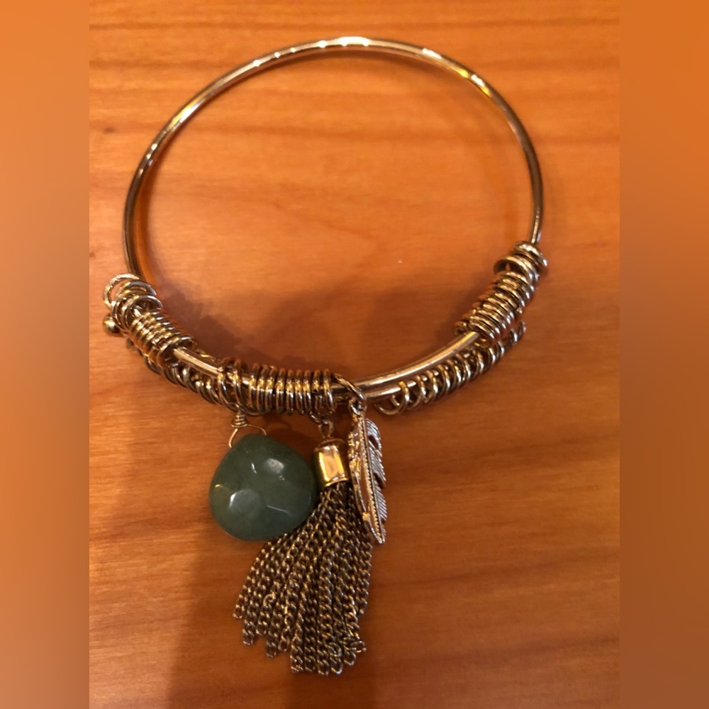 Gold tone bracelet with feather and green bead